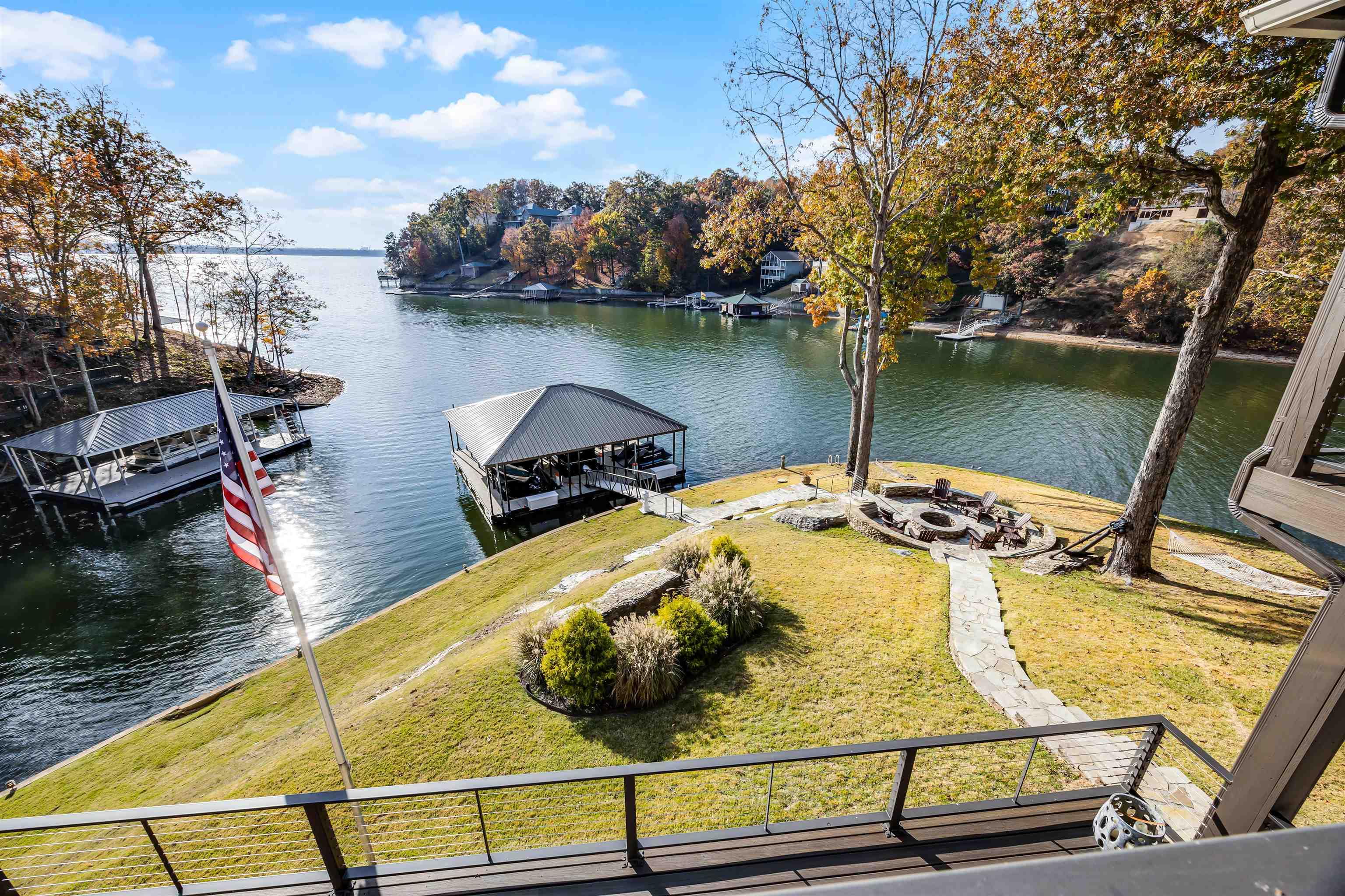 Image 3: Dock featuring a water view, boat lift, a yard, and an outdoor fire pit