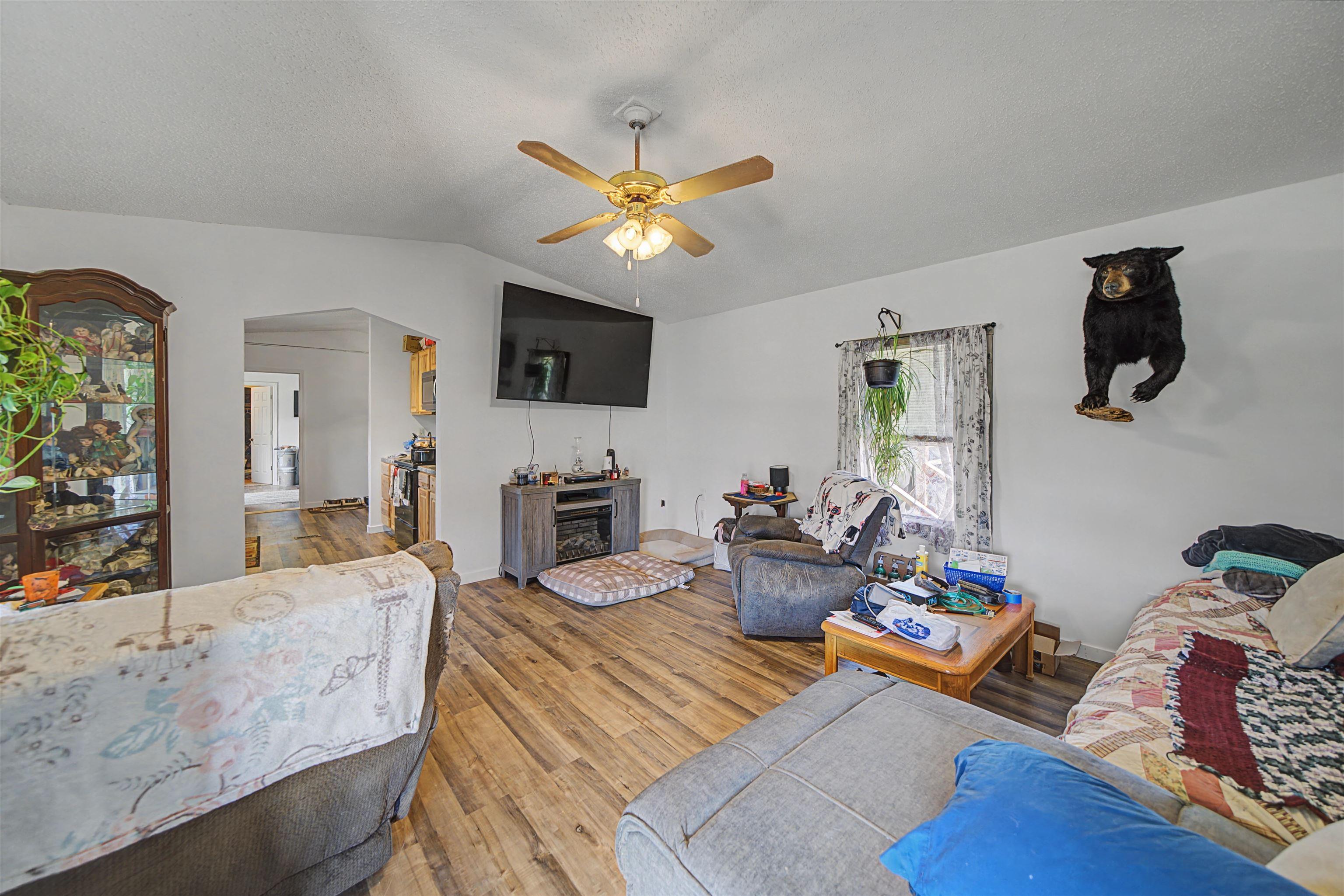 Image 4: Living room with a ceiling fan, wood finished floors, and arched walkways