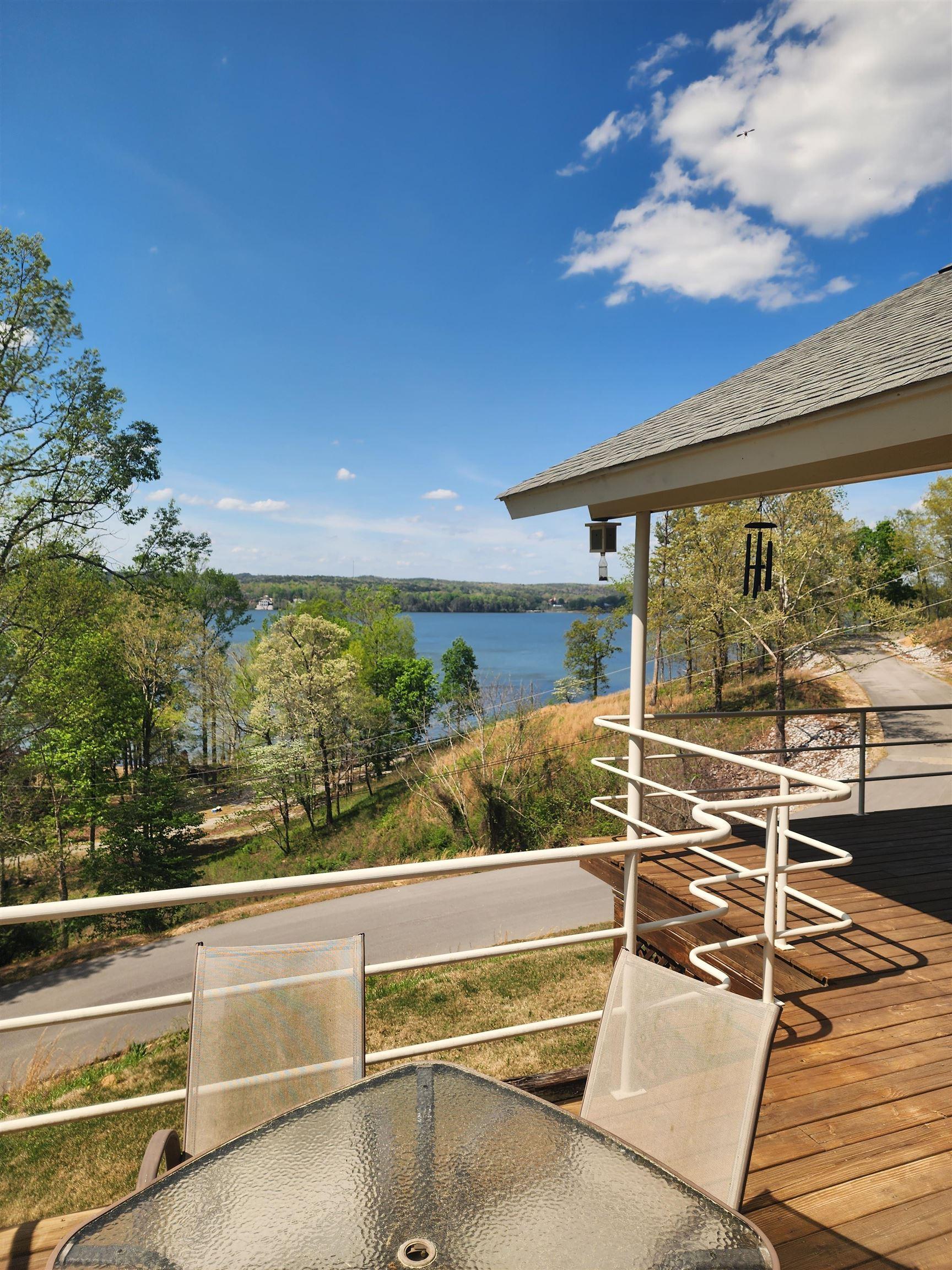 Image 2: Expansive wood-finish deck with a white railing system, featuring a partial roof overhang
