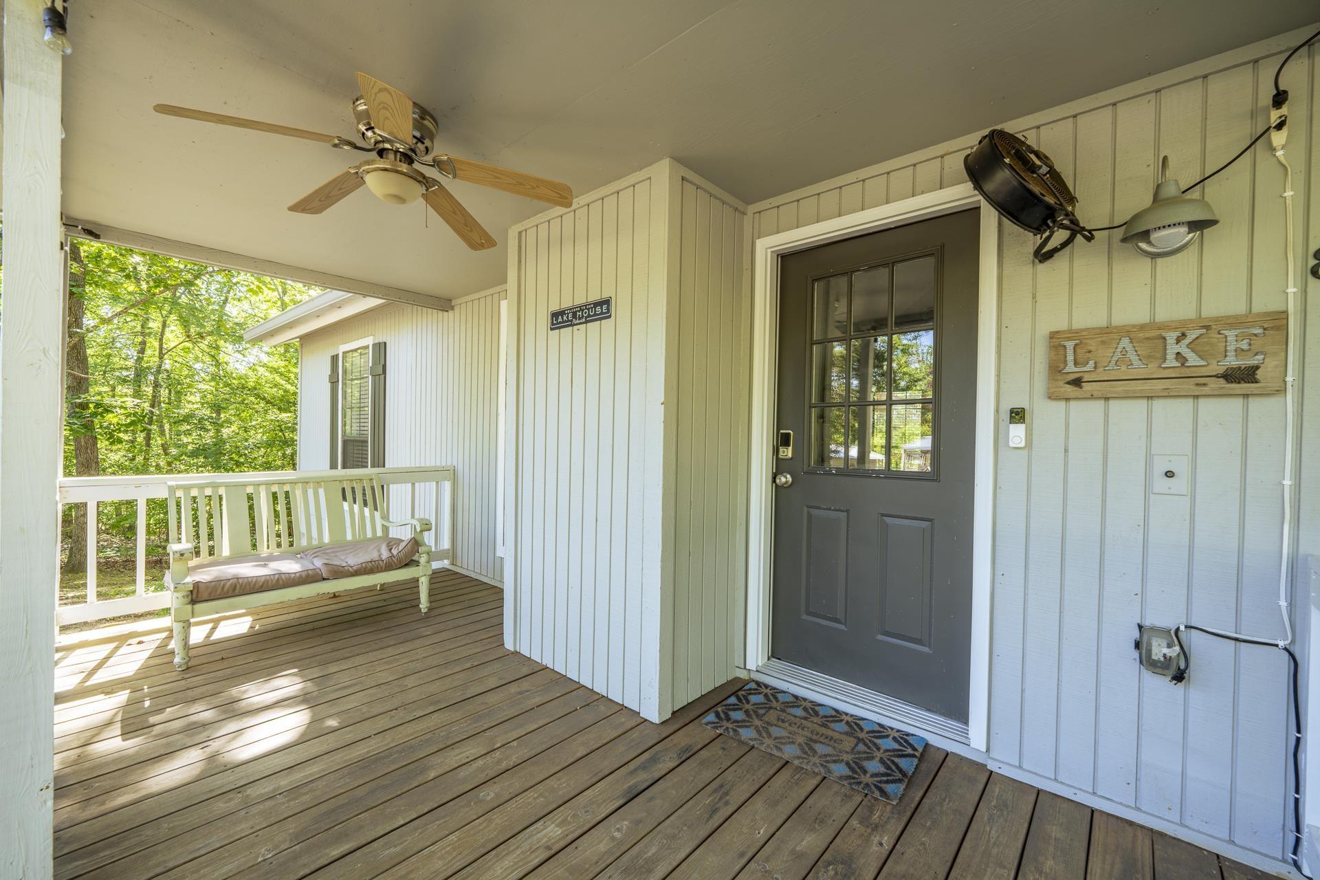 Image 4: Covered porch entry featuring wood-finish flooring, a ceiling fan, and a paneled entry door with windowpanes