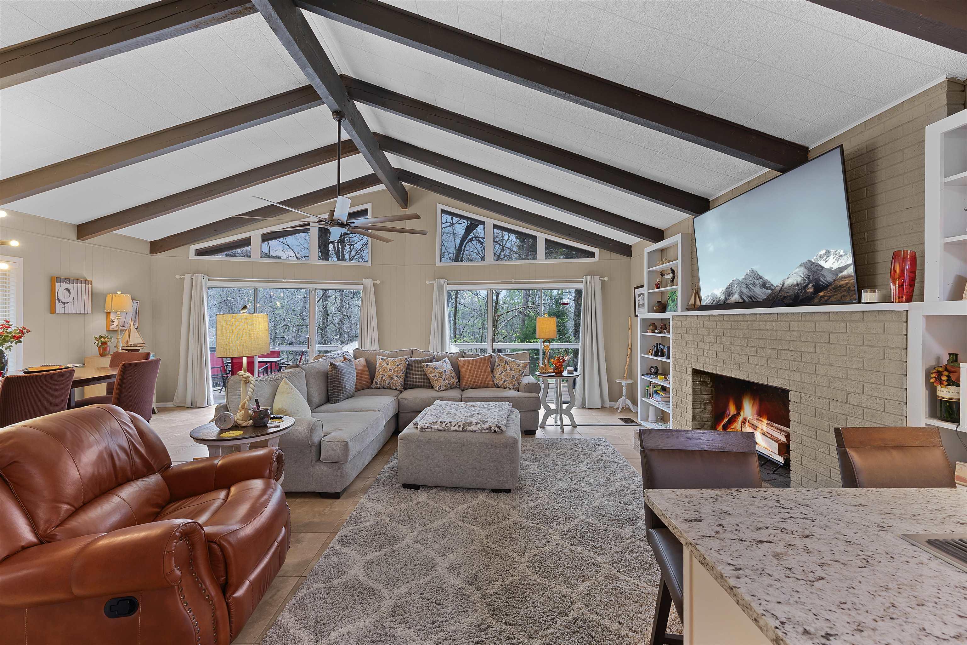 Image 4: Living room with a brick fireplace and ceiling fan