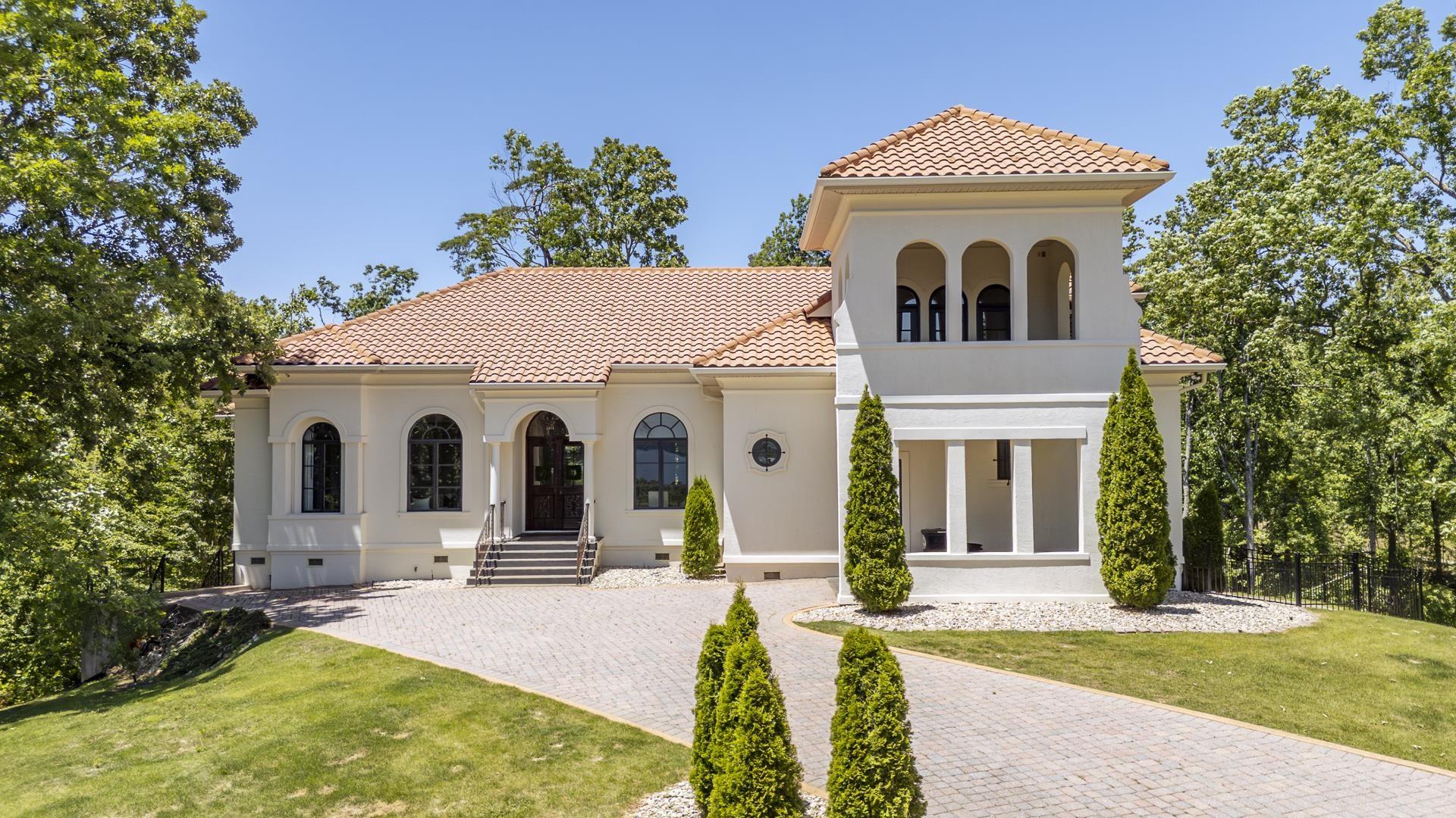 Image 1: Stucco exterior residence with a tile roof and a prominent architectural tower
