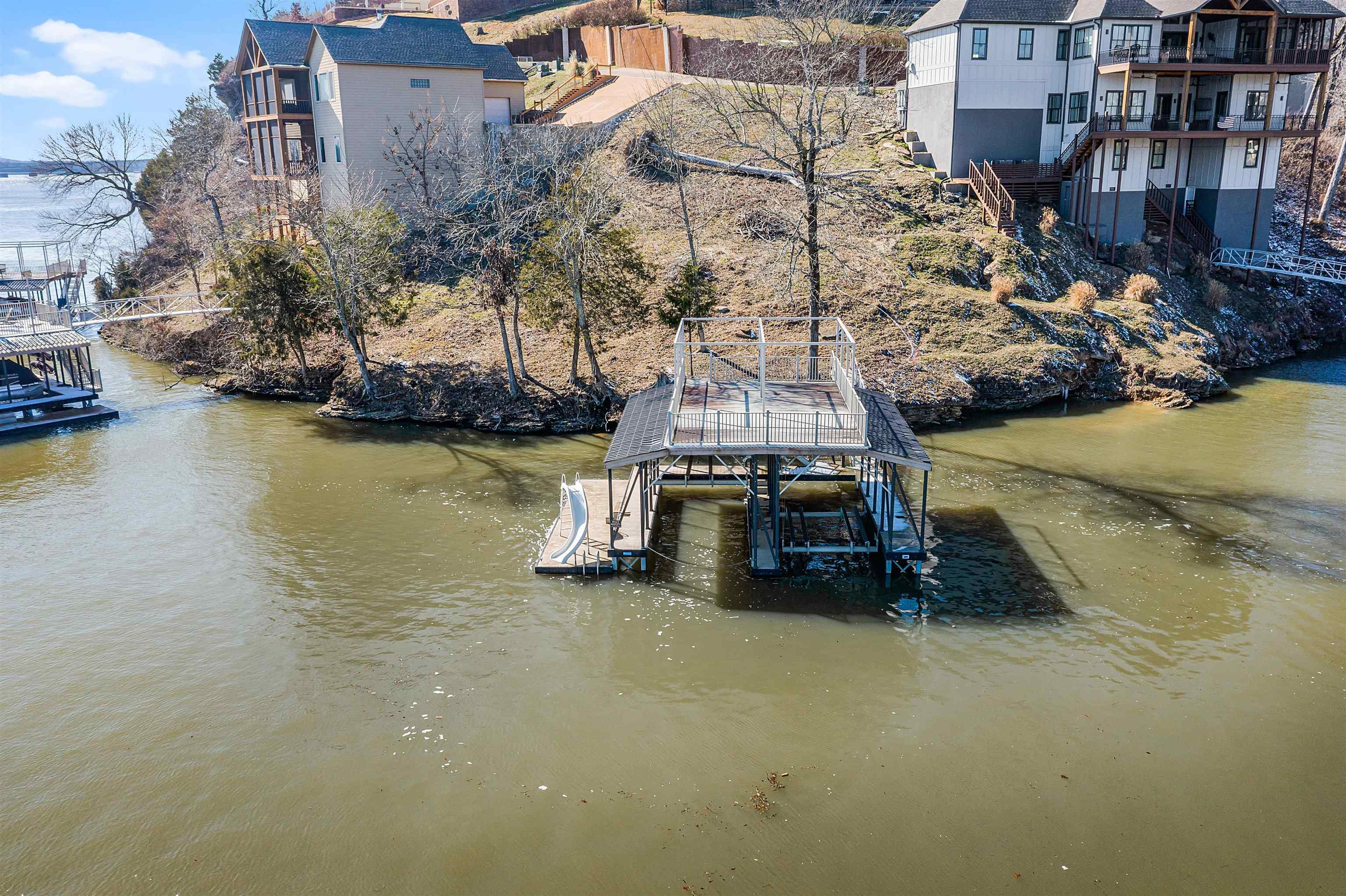 Image 1: Dock area with a water view, boat lift, and stairs