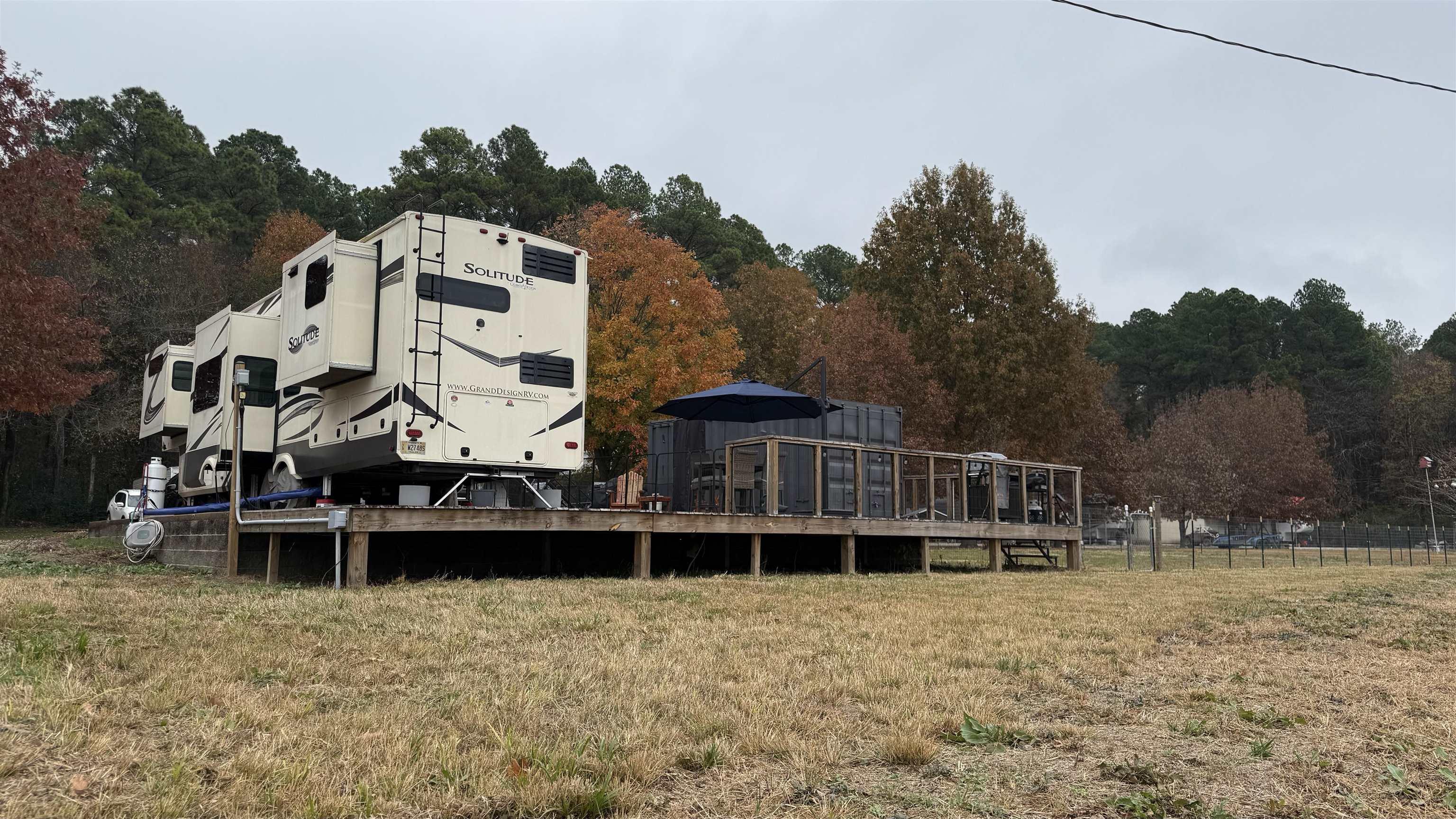 Image 1: Back of property featuring a deck and a yard