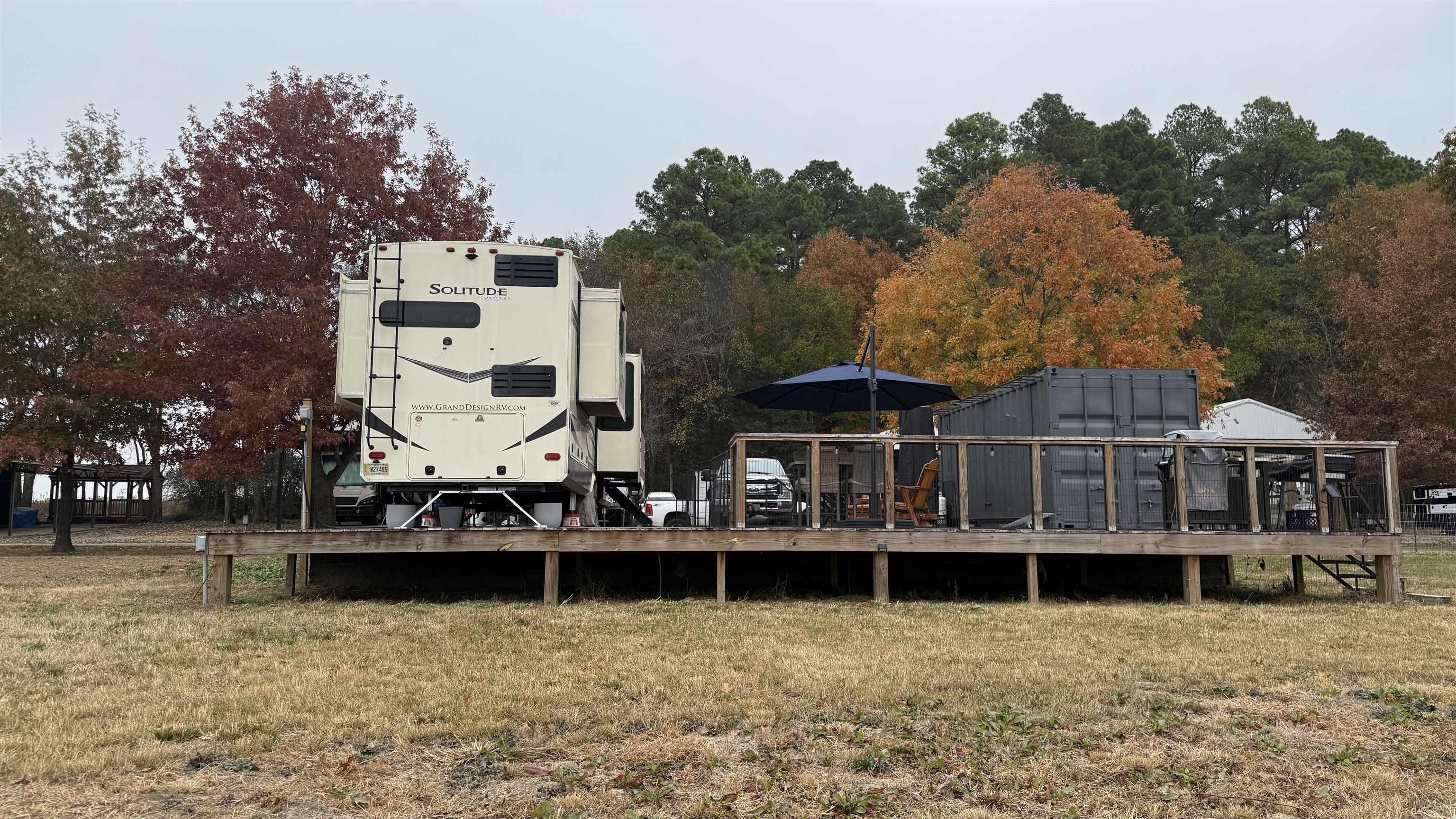 Image 2: Rear view of property with a wooden deck, a lawn, and an outbuilding