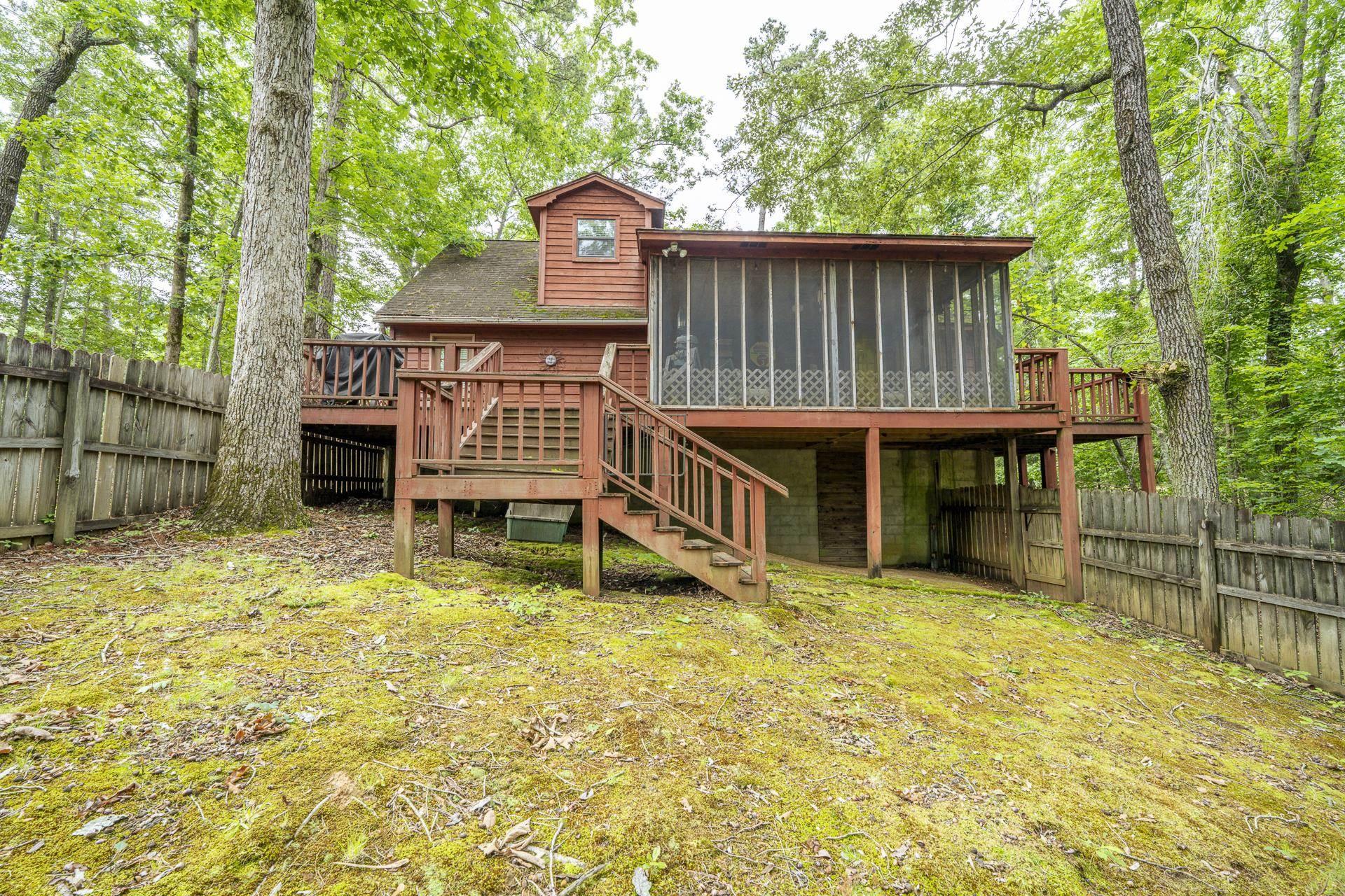 Image 3: Wood-sided property featuring a screened porch and multiple elevated deck spaces
