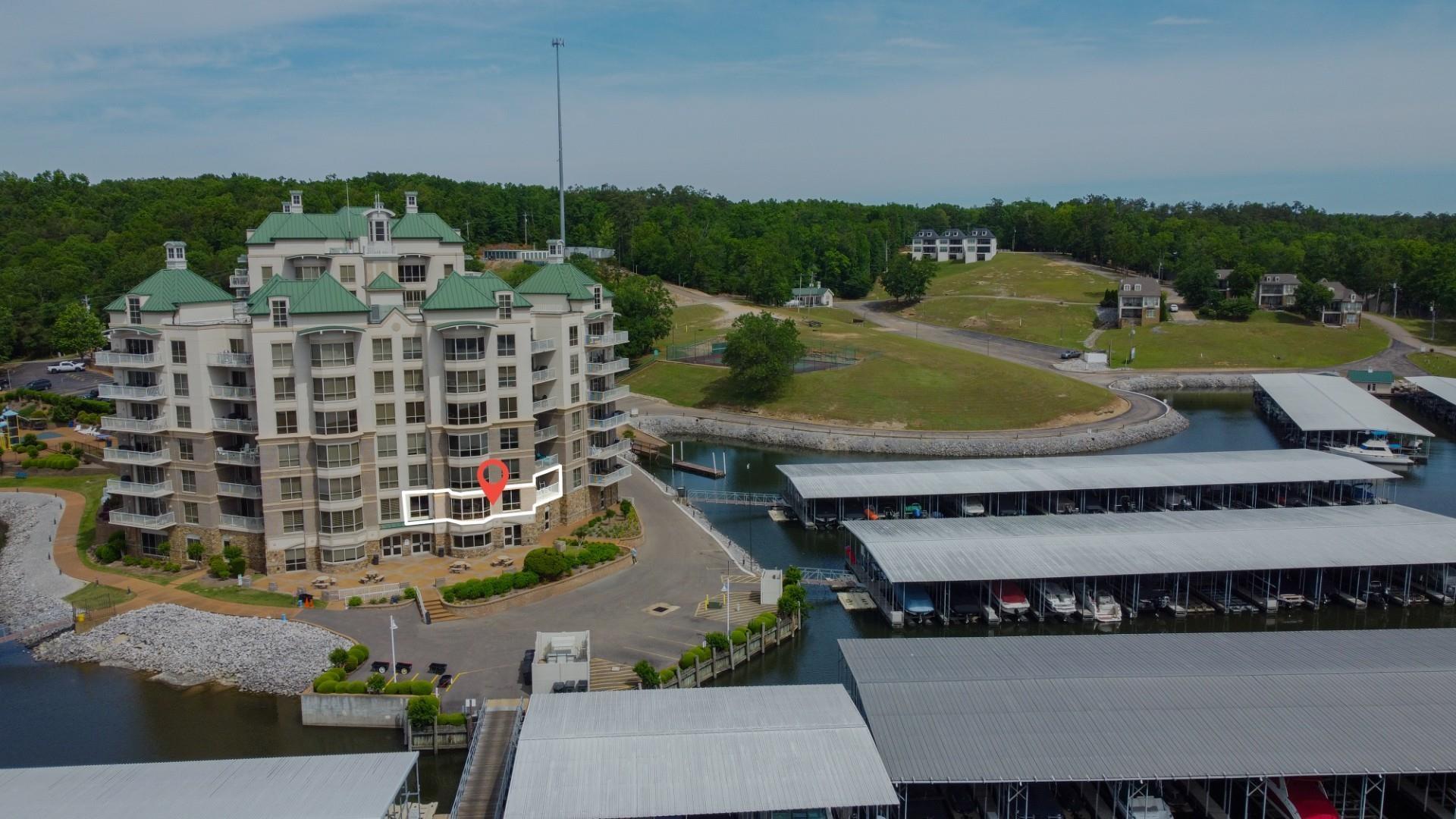Image 4: Waterfront condominium building with multiple balconies, green sloped roofs, and an expansive marina