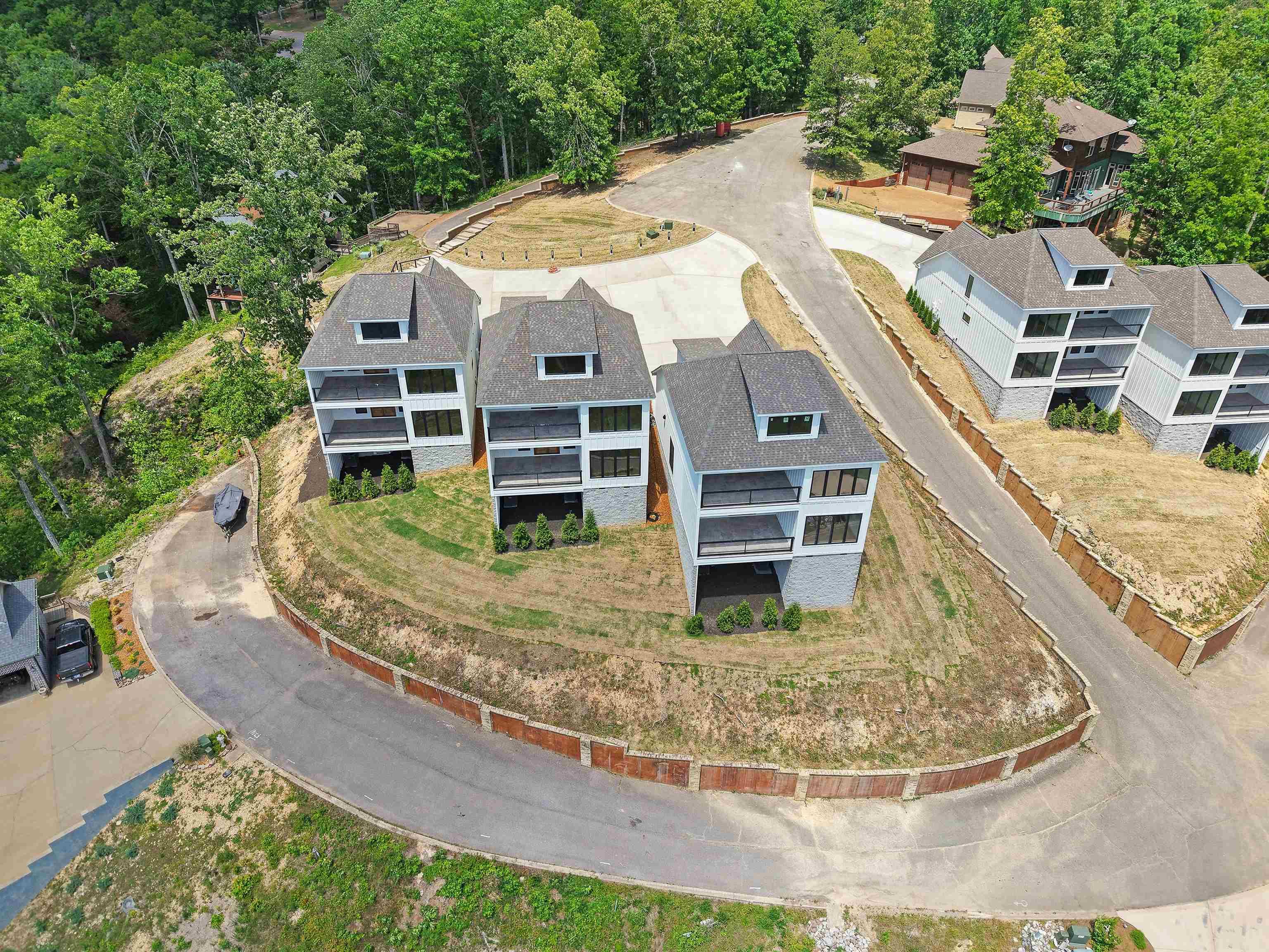Image 3: Contemporary multi-level residences featuring stone foundations, light-colored siding, and dark-shingled gable roofs