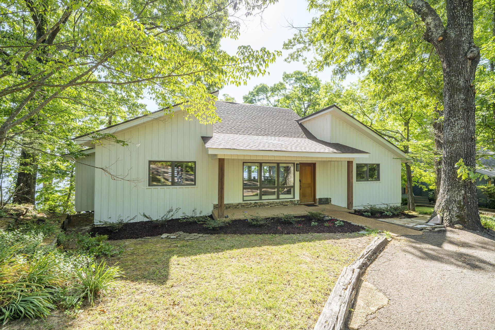 Image 3: Modern-style residence with white vertical siding and a dark shingle roof