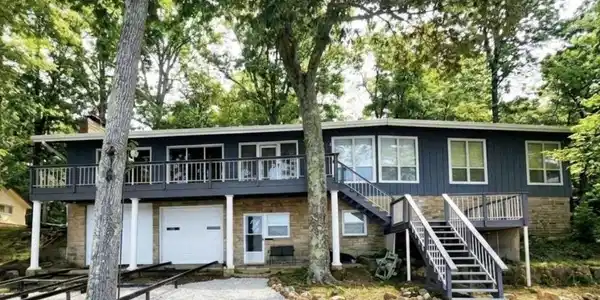 Image 3: Two-story residence featuring a stone and siding exterior