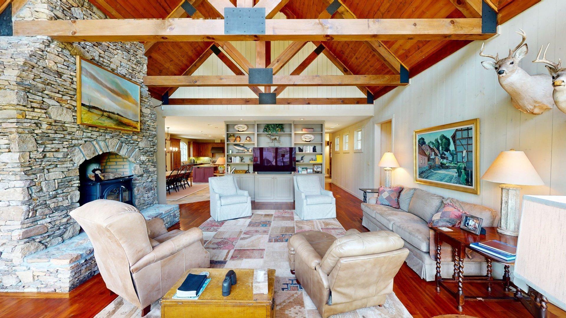 Image 4: Living area featuring high vaulted ceiling, wood finished floors, wood ceiling, a wood stove, and beamed ceiling