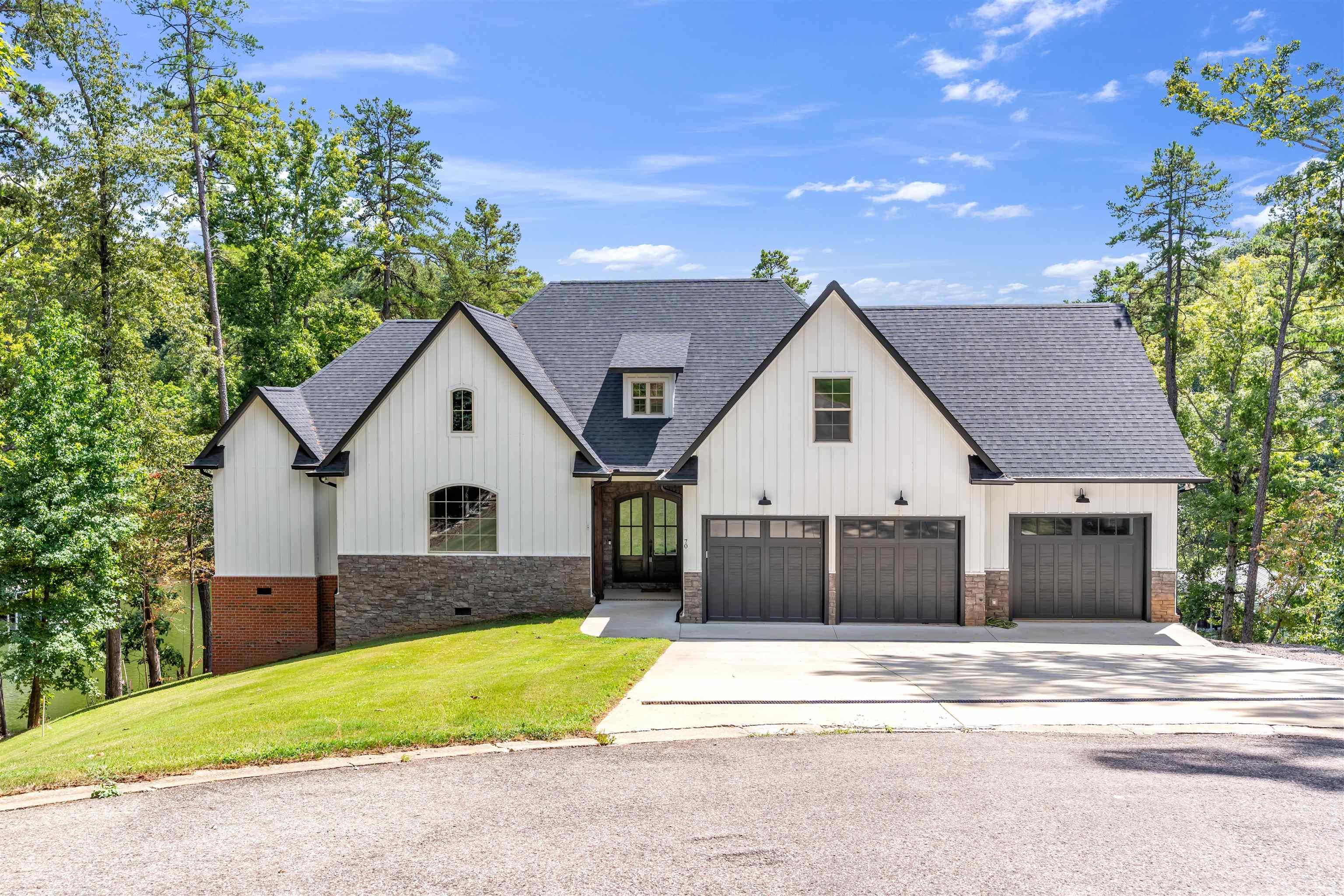Image 1: Modern farmhouse style home featuring roof with shingles, concrete driveway, board and batten siding, a front yard, and a garage