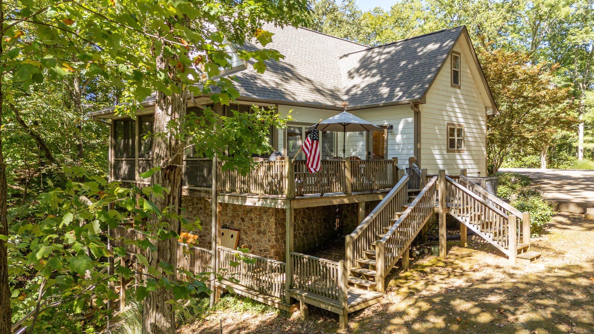 Image 1: Exterior space featuring stairs, a shingled roof, a wooden deck, and stone siding