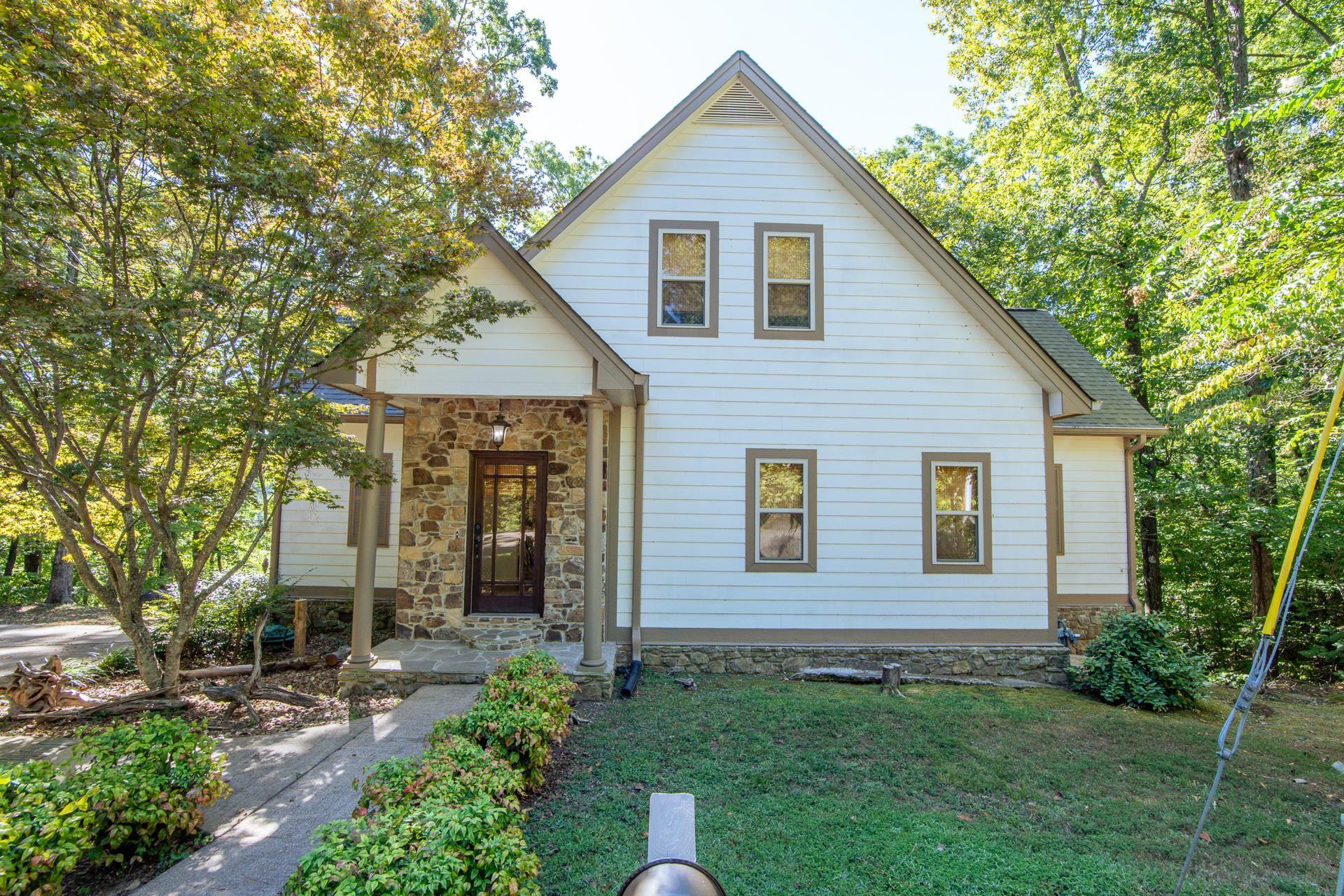 Image 3: View of front of property featuring roof with shingles, a front yard, and stone siding