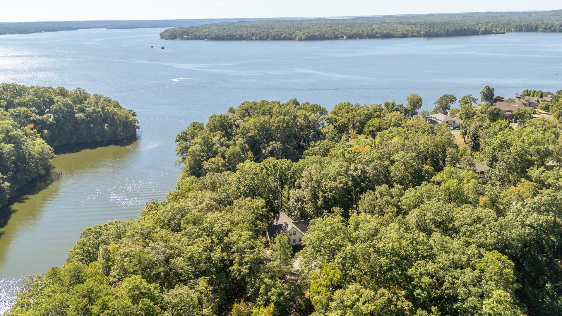 Image 4: Drone / aerial view of a heavily wooded area and a nearby body of water