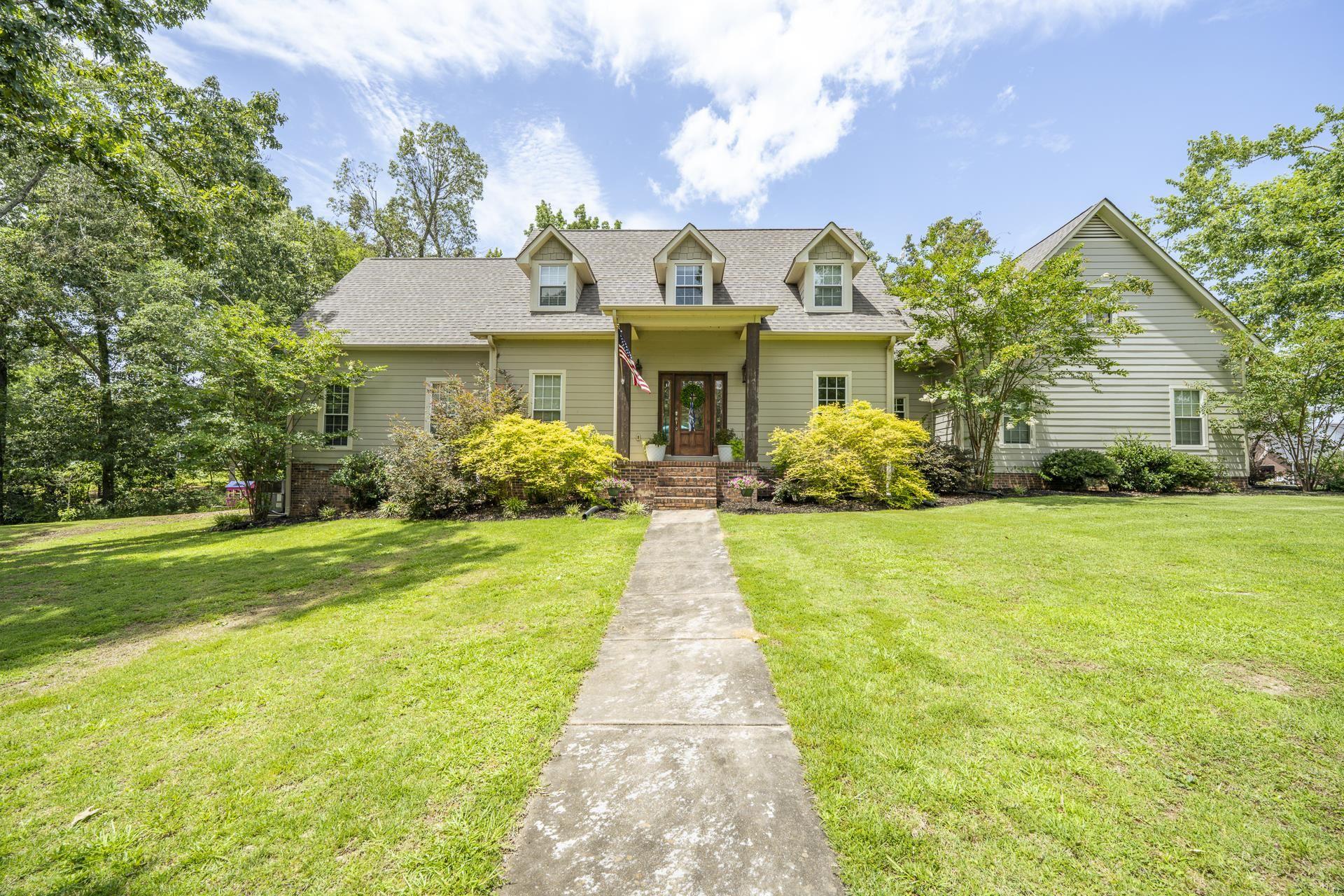 Image 3: Traditional-style home featuring light green siding, a gabled roof, and three dormer windows