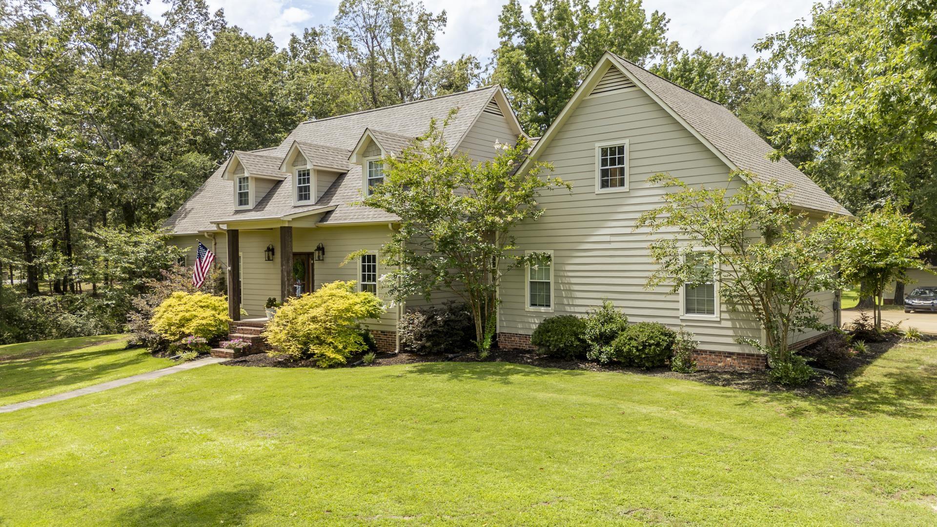 Image 4: Spacious exterior with light-colored siding, a prominent front porch with pillars, multiple dormer windows, a pitched roofline, and established landscaping