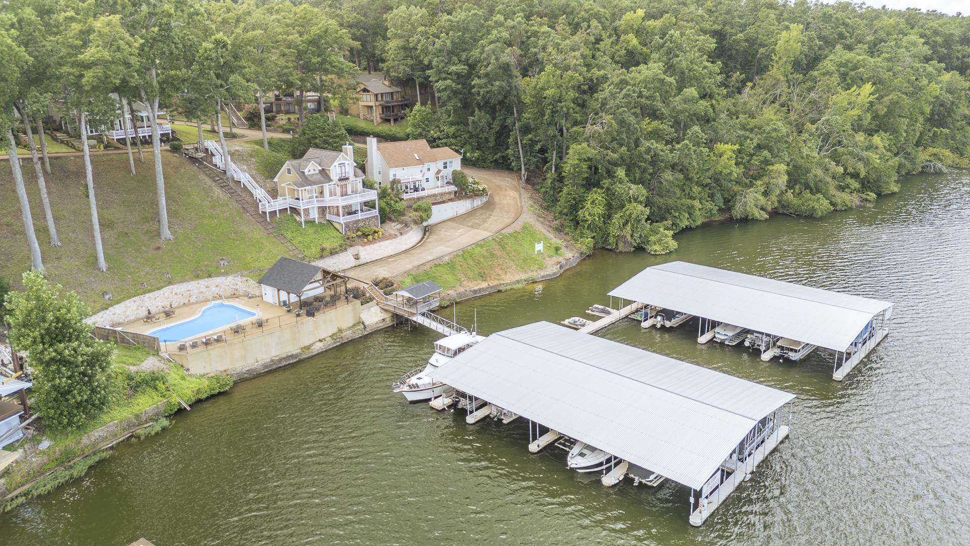 Image 4: Expansive waterfront property featuring two covered boat docks, a private swimming pool, and a poolside cabana