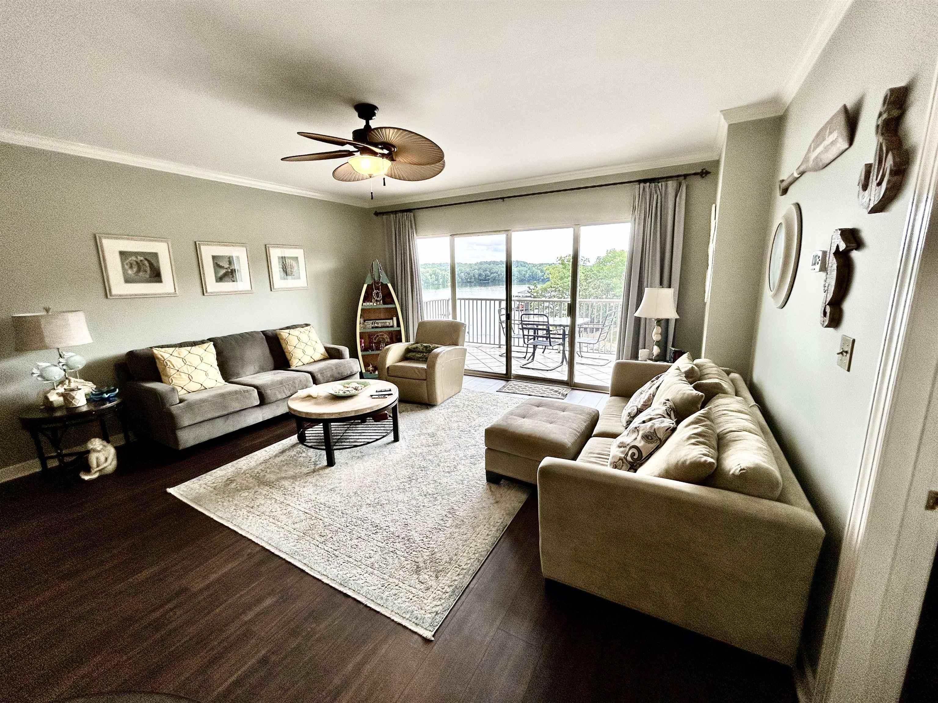 Image 4: Living area featuring crown molding, a ceiling fan, wood finished floors, and a water view