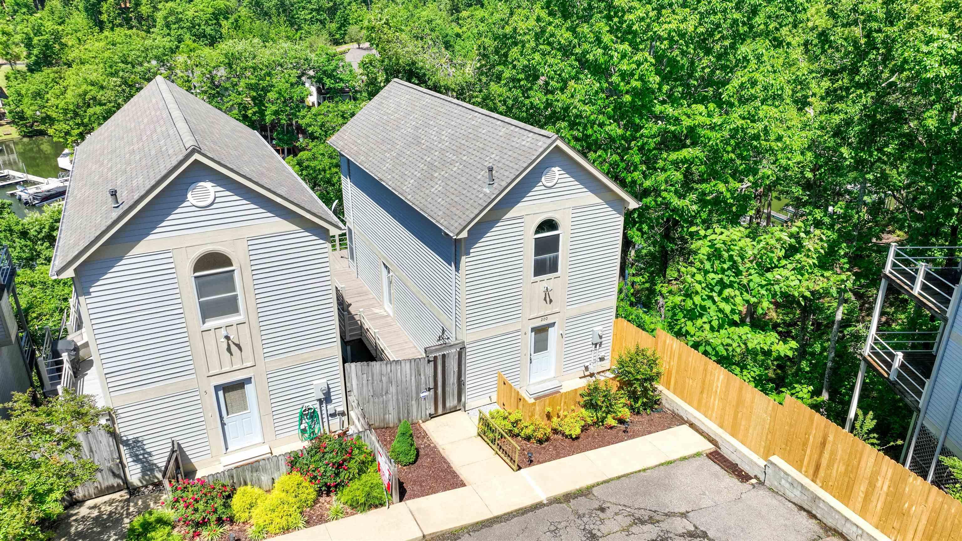 Image 2: Light blue siding exterior featuring an arched window, a covered entry, and an asphalt shingle roof