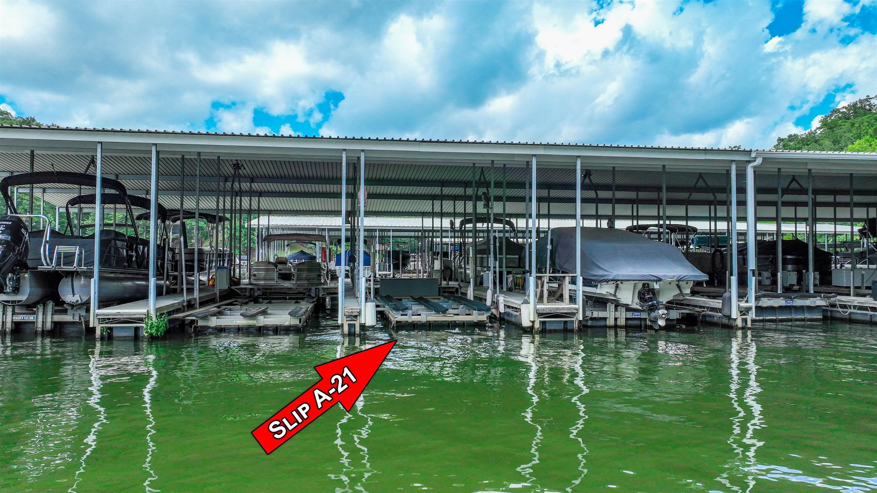 Image 4: Dock featuring boat lift and a water view