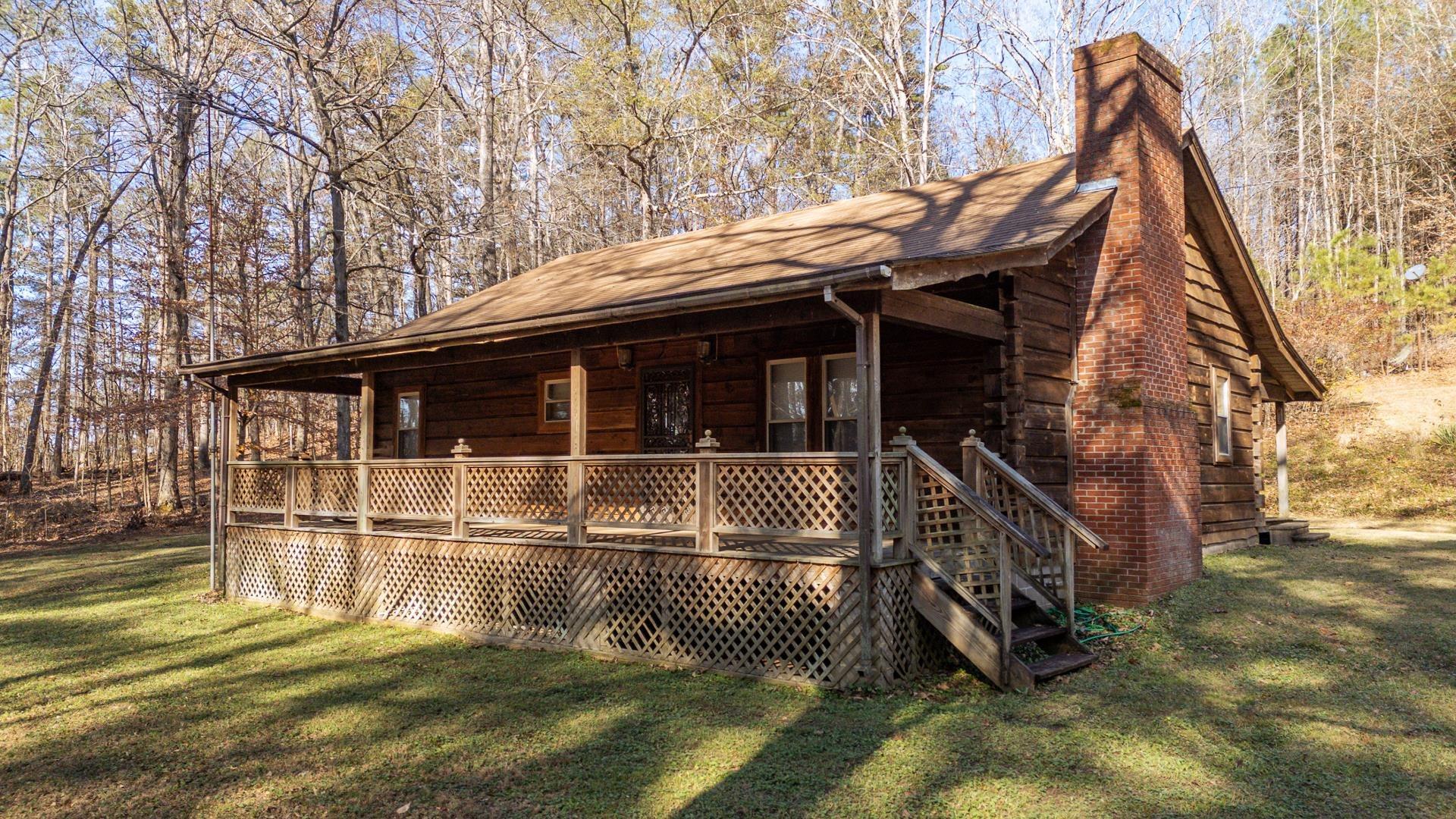 Image 1: View of front of house with a chimney, a front lawn, and covered porch