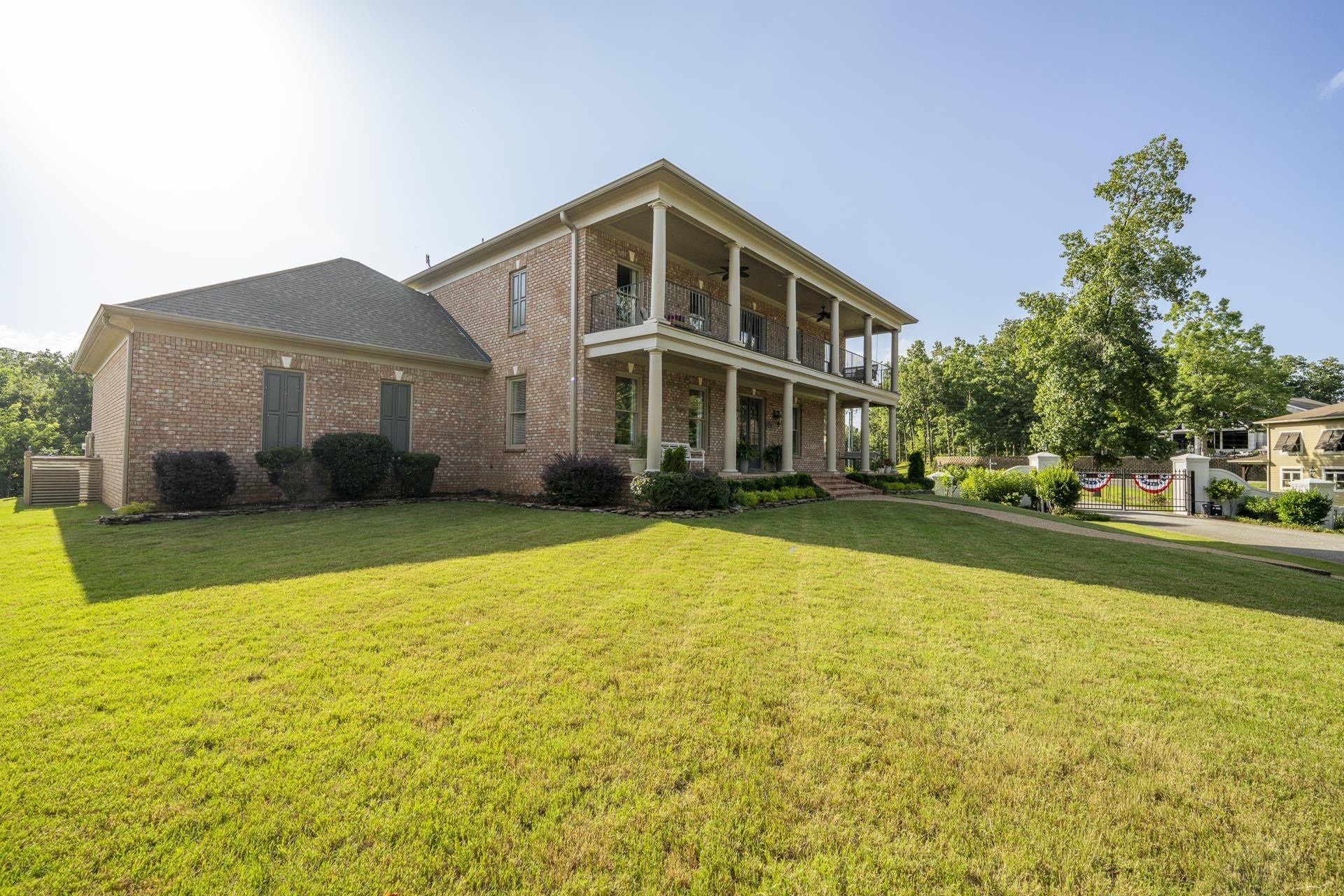 Image 2: Brick exterior with multi-level covered porches featuring white columns