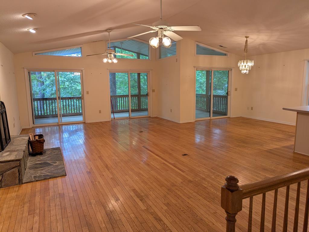 Image 2: Main Level Living/Dining/Kitchen, Open main level with full deck overlooking the wooded lot. Partial winter water view