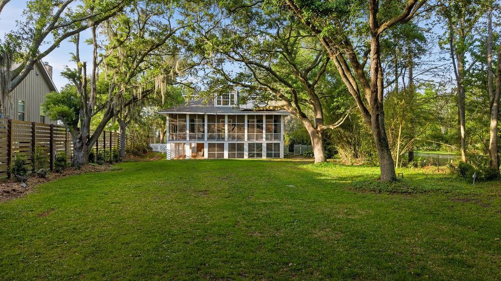 Image 3: Expansive backyard with mature trees and screened