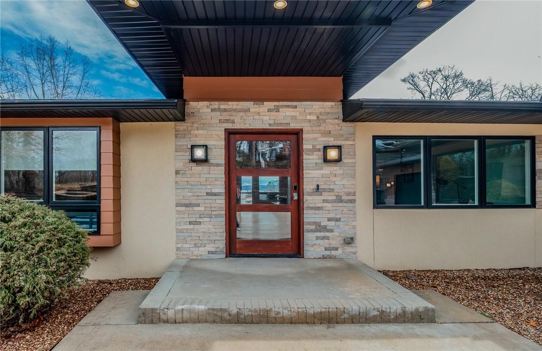 Image 2: Property entrance with stucco siding and stone sid