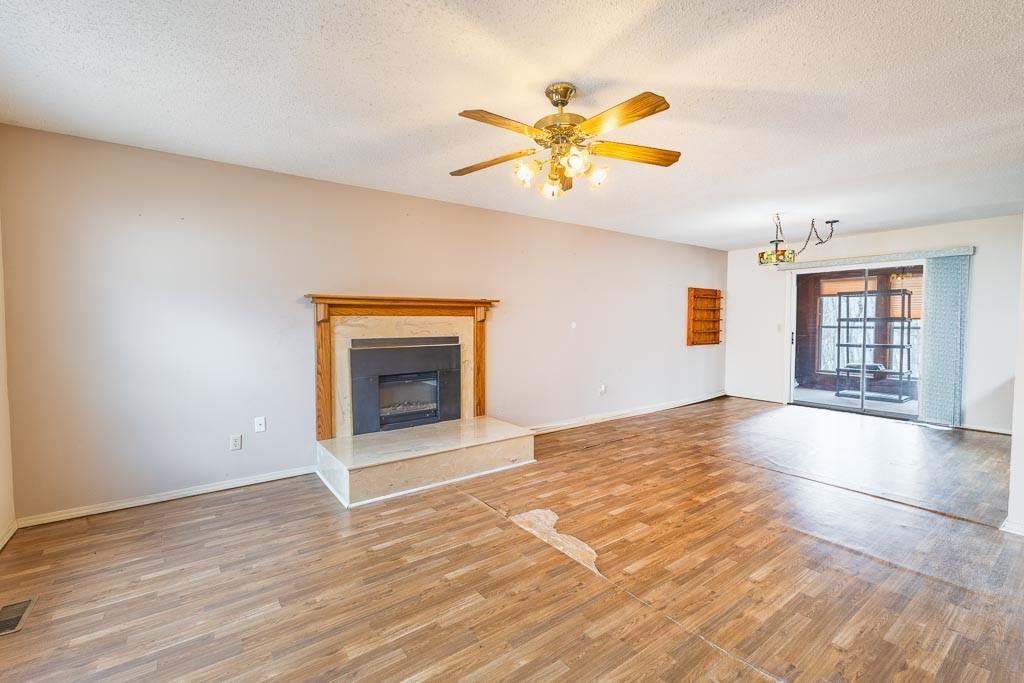 Image 4: Spacious living area featuring a fireplace with a