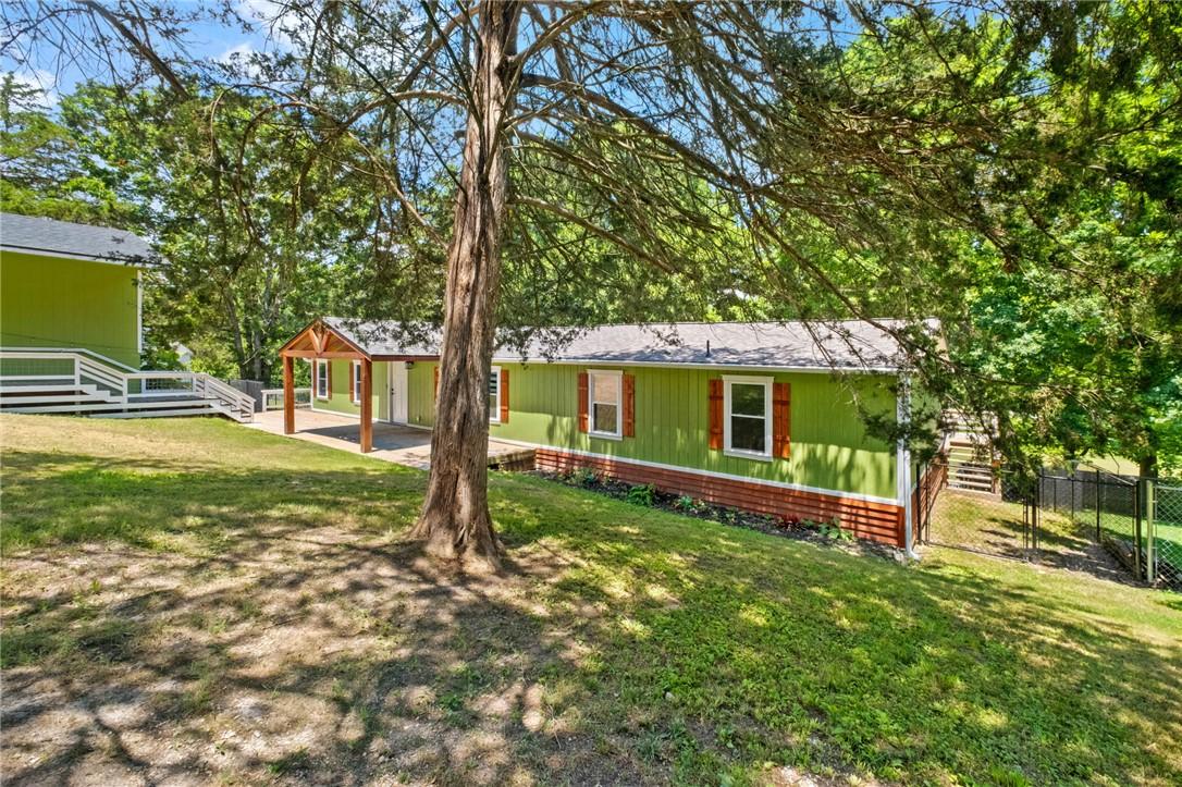 Image 3: Lime green siding exterior with a brick foundation
