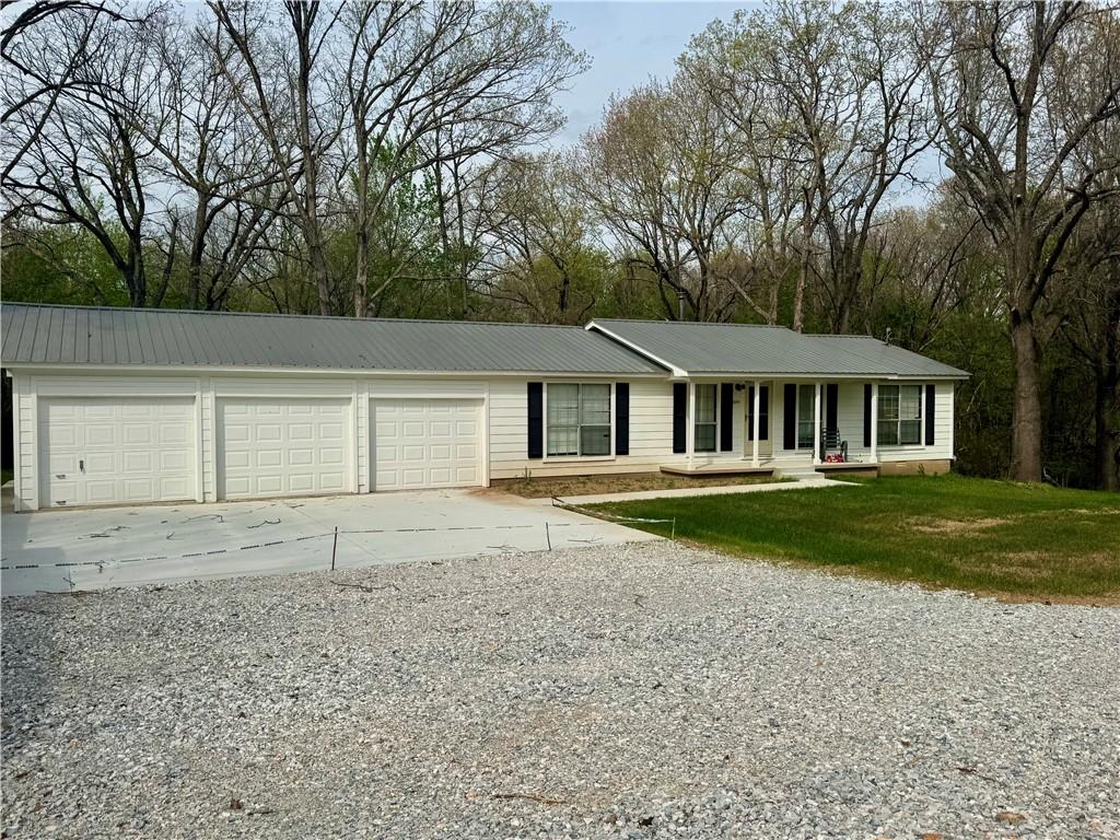 Image 1: Single story home featuring driveway, a metal roof