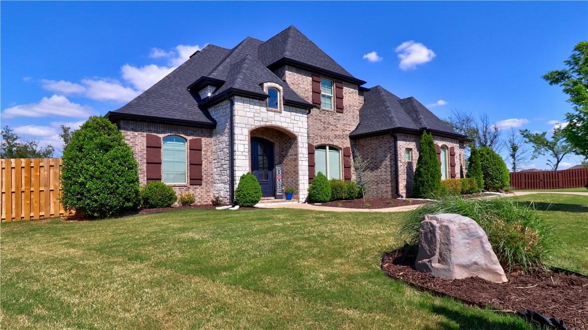 Image 3: Brick and stone exterior featuring dark shutters,