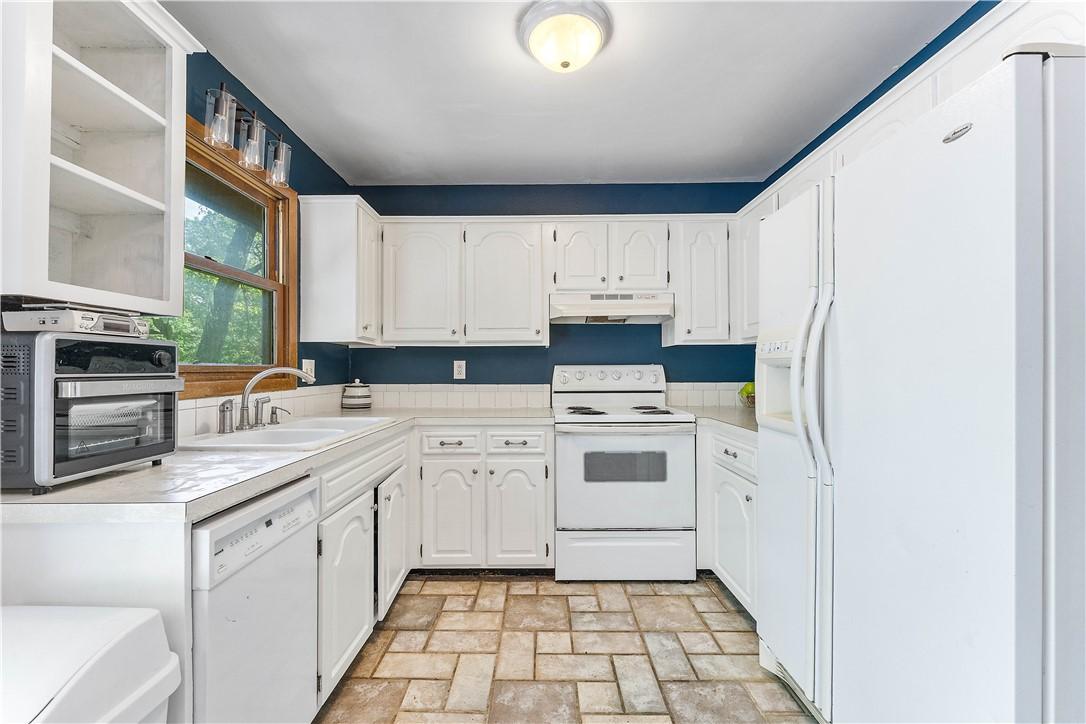 Image 1: Kitchen featuring extensive white cabinetry, white