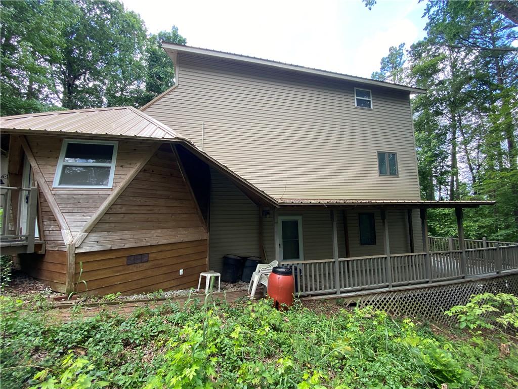 Image 2: Multi-level exterior with beige siding and a metal