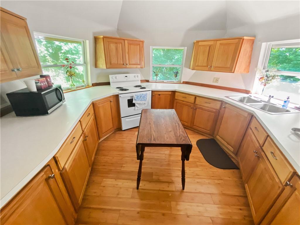Image 4: Kitchen featuring light wood cabinetry, white coun