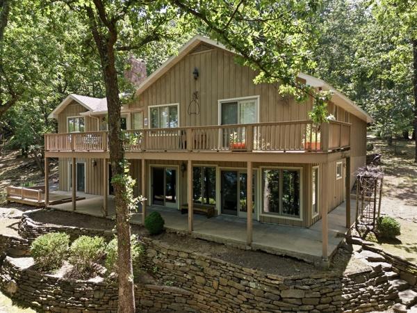 Image 1: Multi-level exterior featuring tan siding, a gable