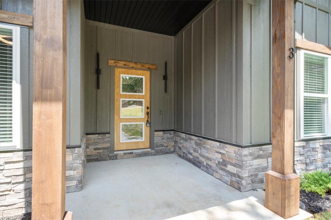 Image 3: Covered front porch featuring a wood-panel entry d