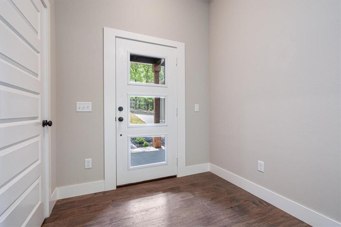 Image 4: Entryway featuring a white door with three rectang