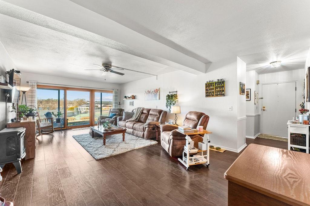 Image 4: Living area featuring a wood stove, a ceiling fan,