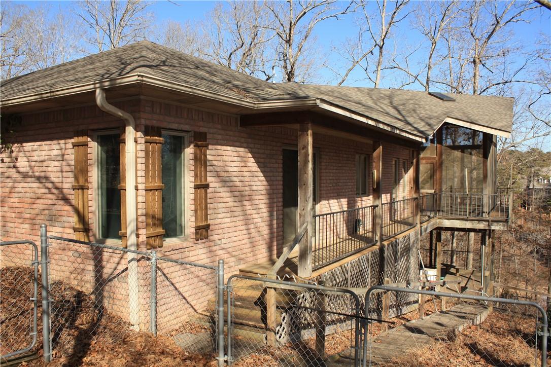 Image 3: View of home's exterior featuring a gate, brick si