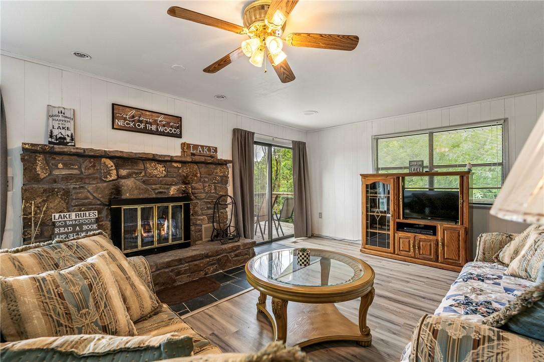Image 3: Living area featuring a stone-clad fireplace with