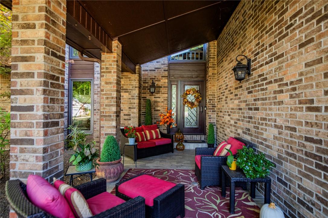 Image 2: Brick exterior featuring a covered entry, dark woo