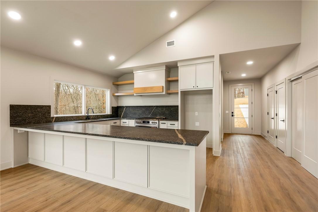 Image 4: Kitchen featuring open shelves, a peninsula, light