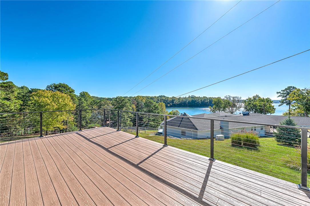 Image 2: Wooden deck featuring a yard and a water view