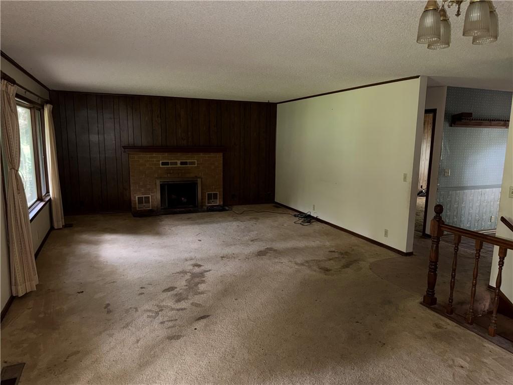 Image 2: Living area featuring a brick fireplace with a dar