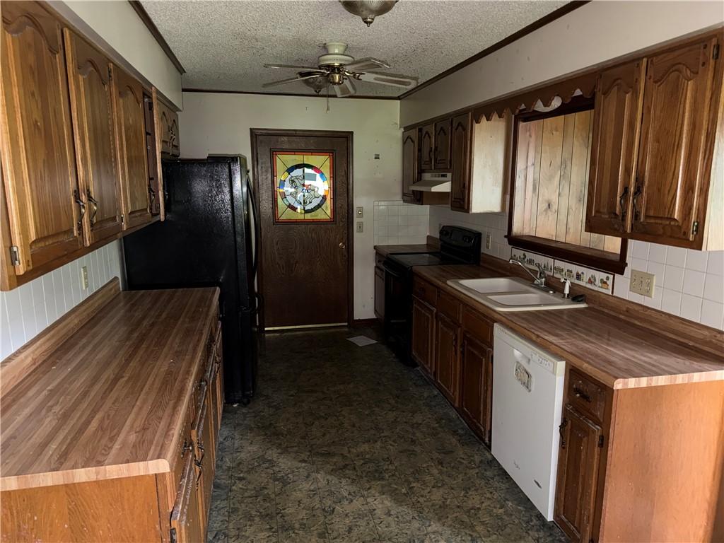 Image 3: Galley kitchen featuring wood-finish countertops,