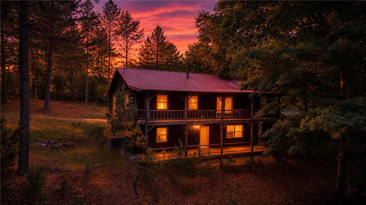 Image 2: Two-story log cabin structure with a red metal roo