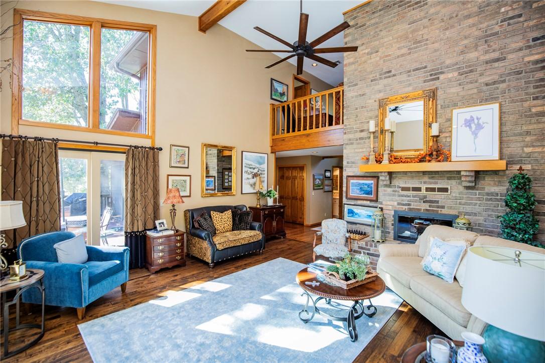 Image 4: Vaulted living room with exposed wood beams, a flo